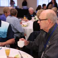 Two alumni sip on coffee and mimosa's at the Alumni brunch.